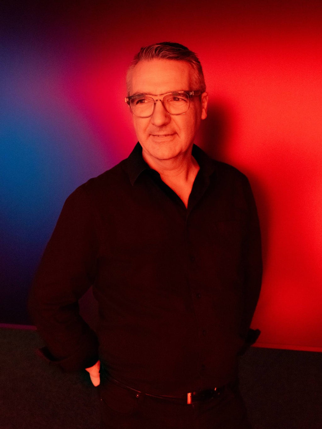 Portretfoto van Audi-designer César Muntada tegen een achtergrond met rood en blauw licht.