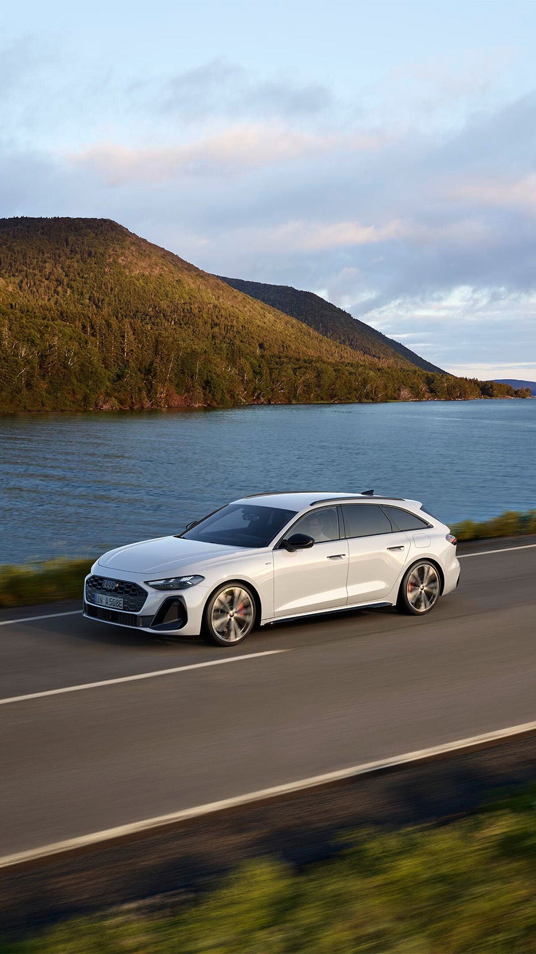 Two Audi cars facing each other side by side with beautiful sky at the back