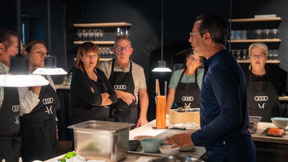 Andreas Caminada neben mehreren Beeten mit Blumen darin