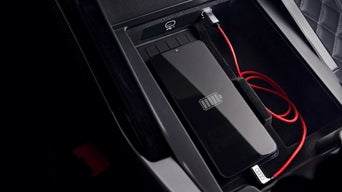 USB Ladekabel von Audi steht innerhalb eines Audis in einem Handy