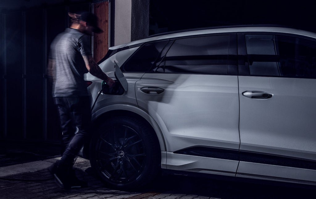 Tom Klocker steckt das Ladekabel in seinen Audi Q4 e-tron.