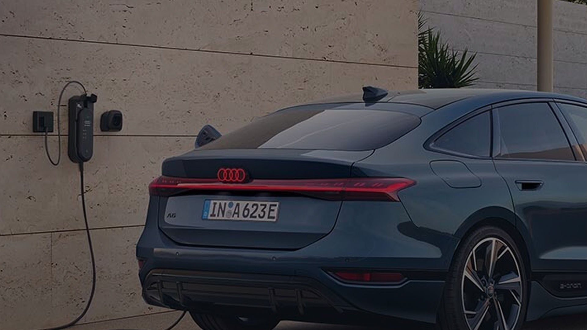 Audi electric vehicle charging against a modern wall, showcasing its futuristic design and eco-friendly technology.