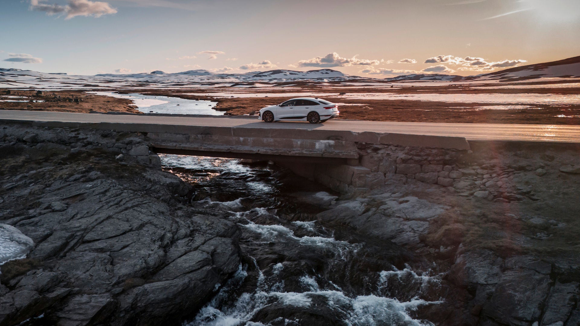 Wide landscape, long road with white Audi A6 Sportback e-tron, designed to cover long distances.