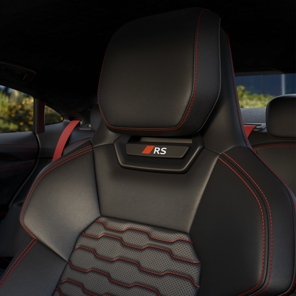 Black leather car seat with red stitching and 'RS' logo on headrest.