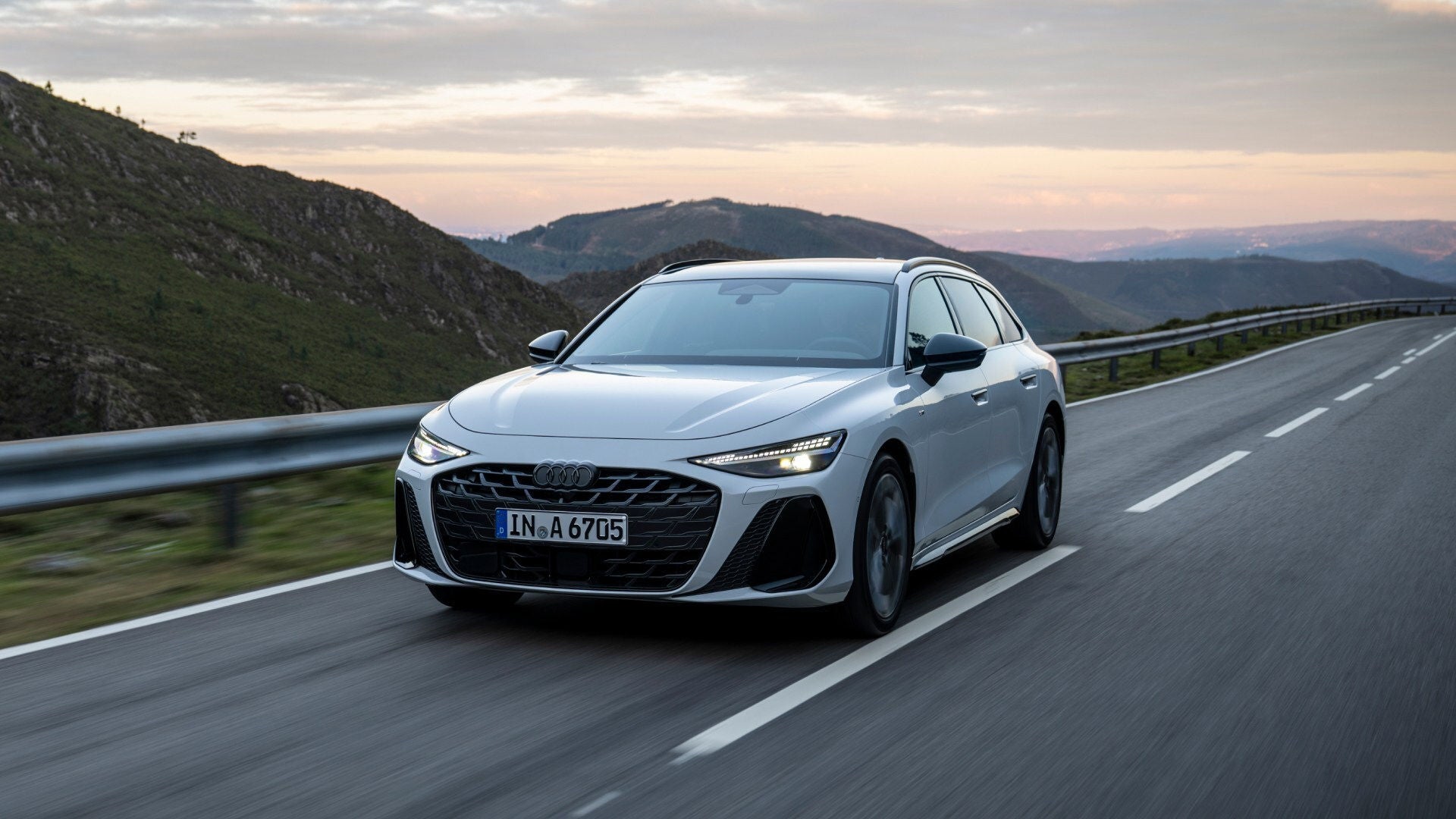 Ein Audi A6 fährt auf einer Straße durch eine felsige Landschaft.