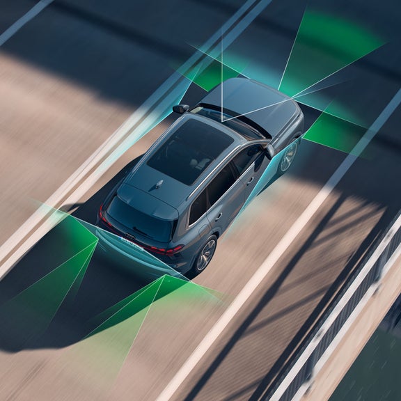 Le SUV Audi Q7 vu en plongée depuis un pont. À l'arrière et à l'avant, des vecteurs verts et bleus divisent les surfaces situées derrière et devant le véhicule.